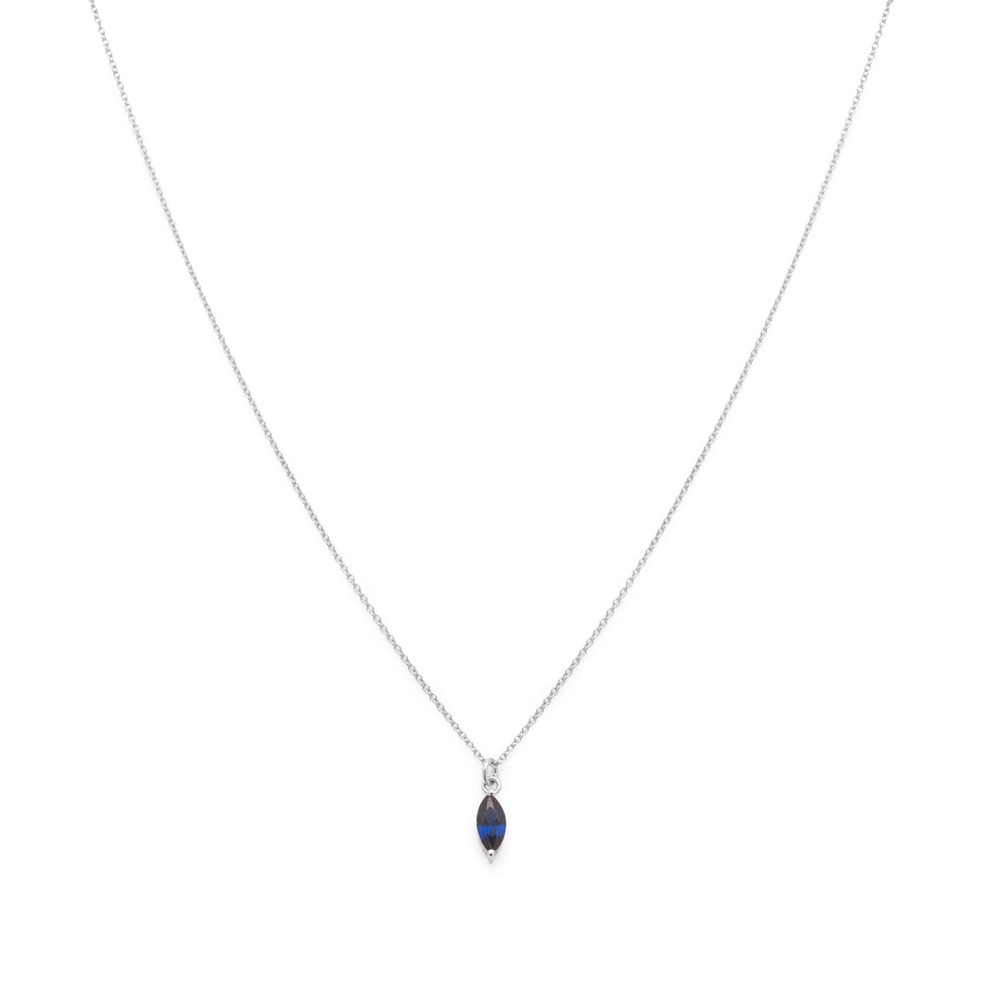 A delicate silver chain necklace featuring a small marquise-cut dark blue pendant in a silver bezel setting, displayed against a solid white background.
