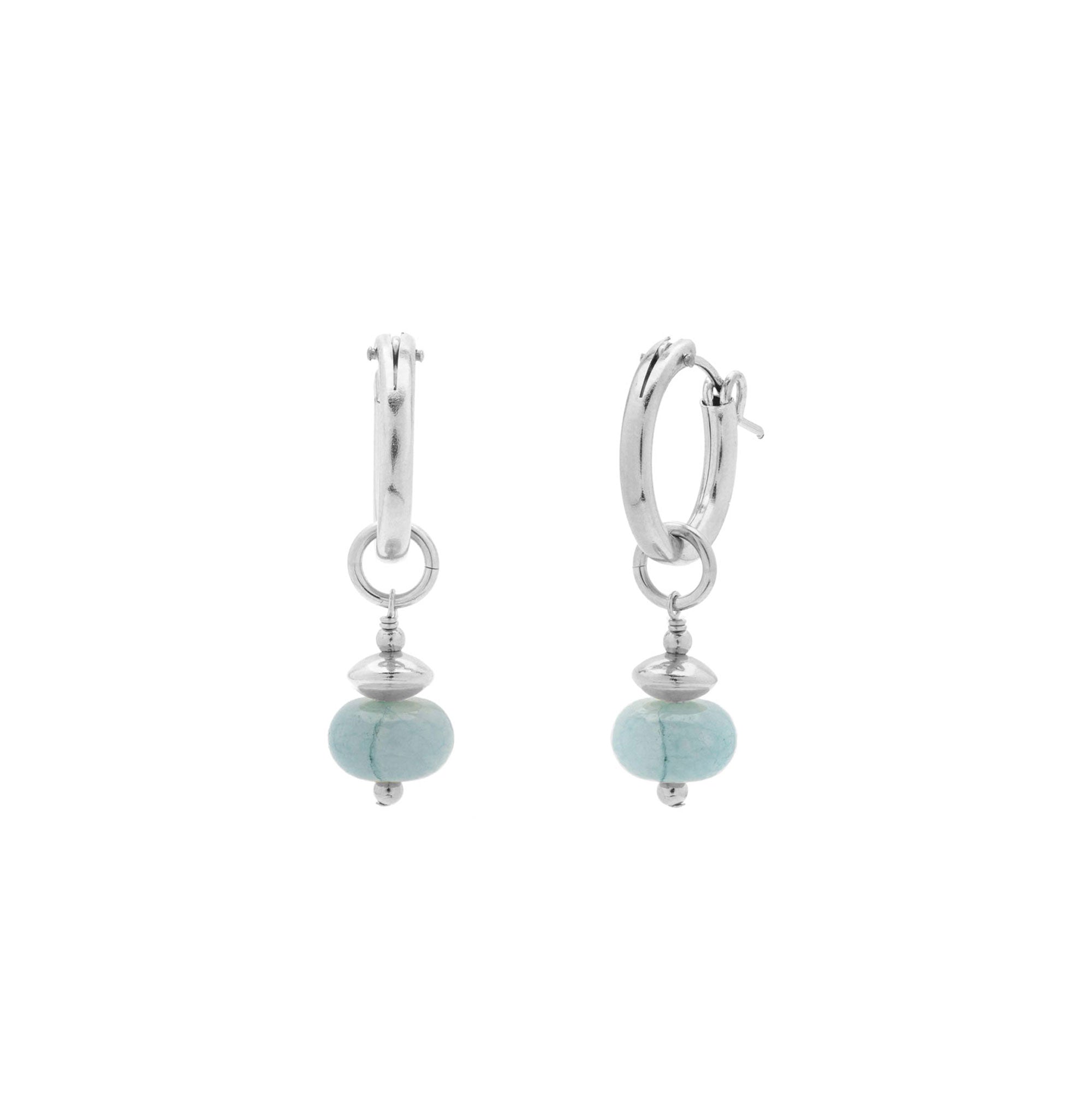A pair of silver huggie hoop earrings with a small silver bead spacer and a light blue-green stone dangle, shown on a plain white background.